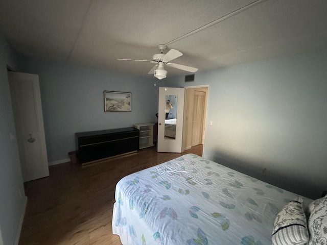 bedroom with a ceiling fan, wood finished floors, and baseboards