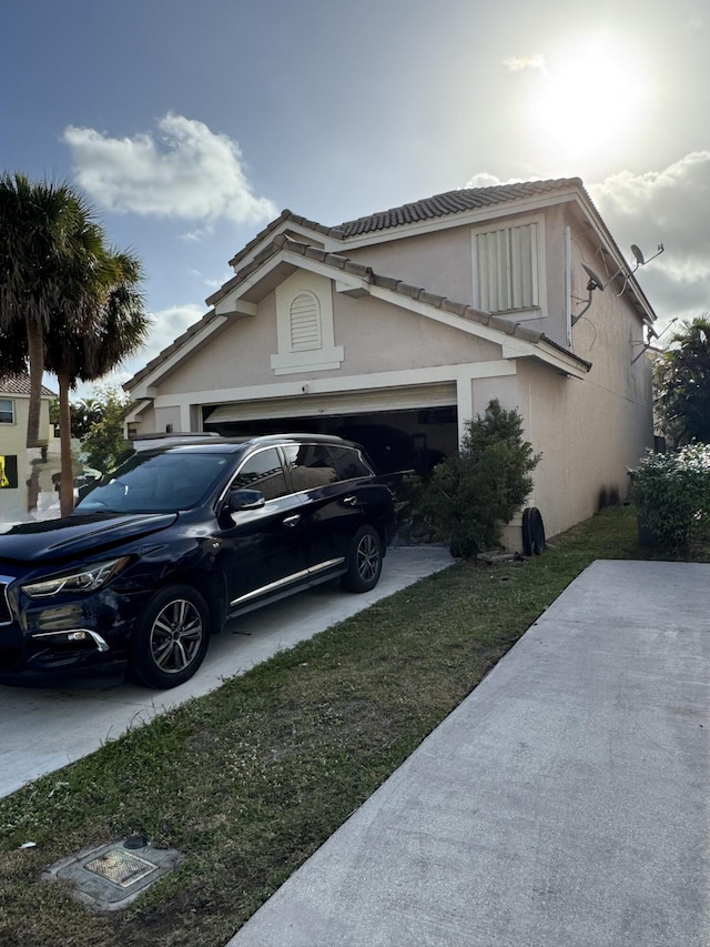 view of property exterior with a garage, driveway, and stucco siding