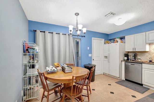 dining room featuring visible vents, a notable chandelier, and a textured ceiling