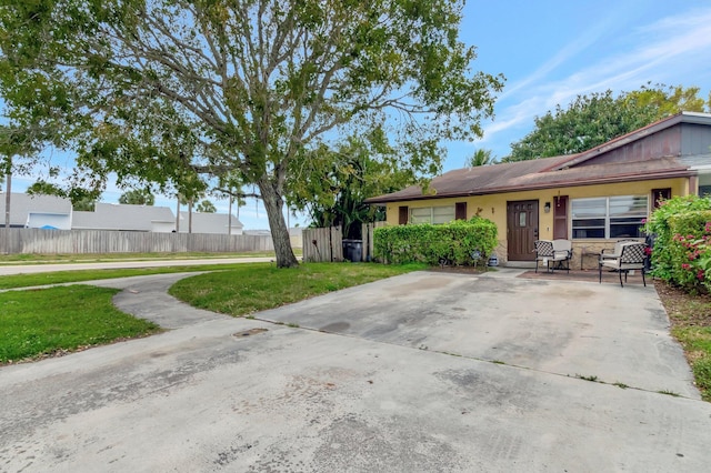 ranch-style house with fence, a front lawn, and stucco siding