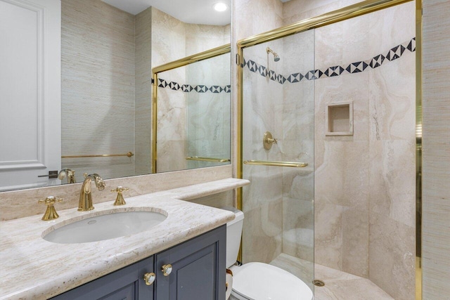 bathroom with toilet, a shower stall, and vanity