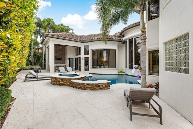 back of property featuring a patio area, a tile roof, stucco siding, and an in ground hot tub