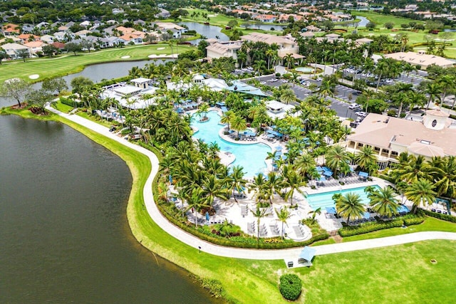 drone / aerial view featuring a water view, view of golf course, and a residential view