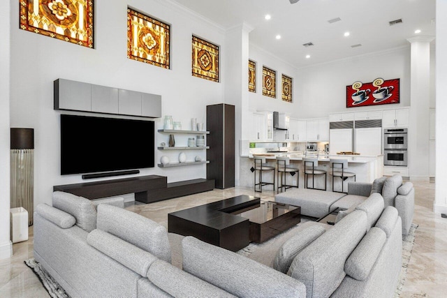 living area with a high ceiling, recessed lighting, visible vents, and crown molding