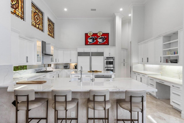 kitchen featuring a peninsula, a high ceiling, a sink, decorative backsplash, and built in desk