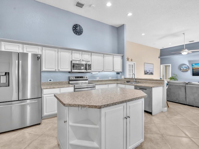 kitchen featuring light tile patterned floors, a peninsula, appliances with stainless steel finishes, and visible vents