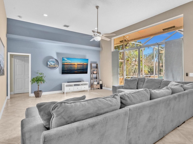 living room with light tile patterned floors, ceiling fan, visible vents, and baseboards