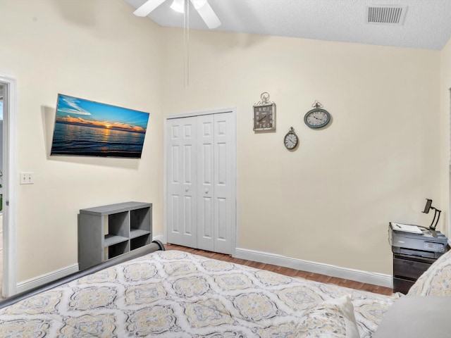 bedroom featuring visible vents, vaulted ceiling, baseboards, and wood finished floors