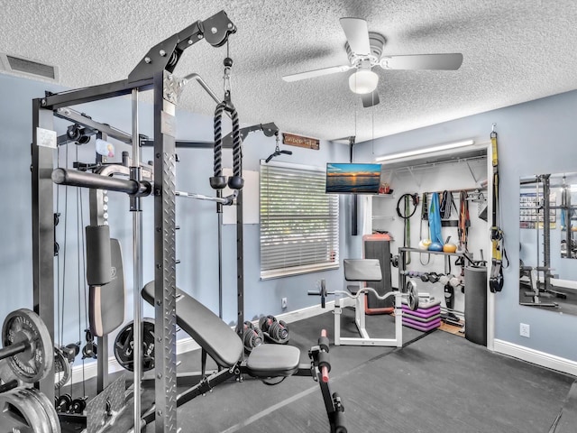 workout room with a ceiling fan, baseboards, visible vents, and a textured ceiling