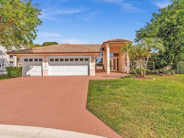 mediterranean / spanish-style home featuring driveway, a tile roof, an attached garage, a front lawn, and stucco siding