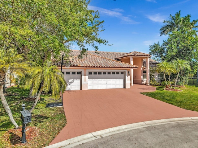 mediterranean / spanish-style house featuring a tiled roof, an attached garage, decorative driveway, a front lawn, and stucco siding