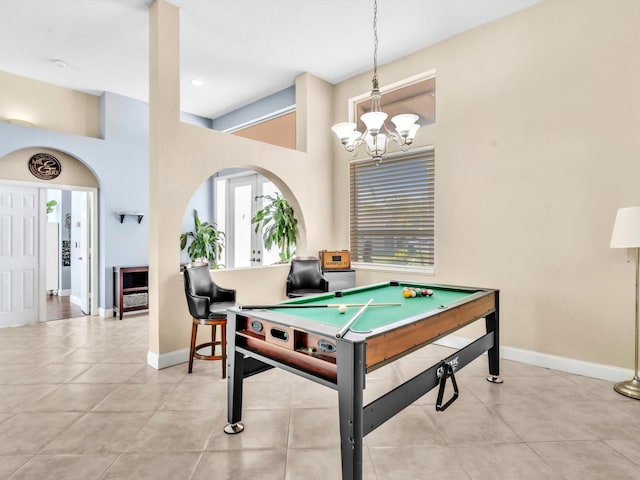 playroom featuring light tile patterned floors, baseboards, and arched walkways