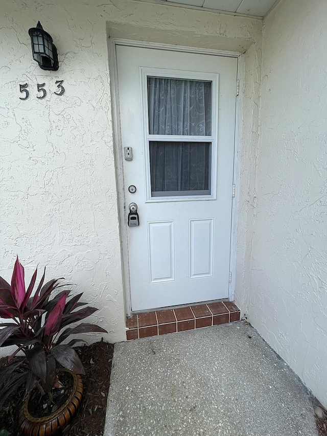 entrance to property featuring stucco siding