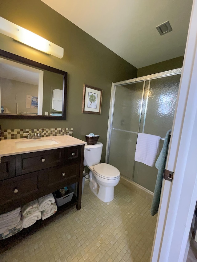 bathroom with toilet, a shower stall, tasteful backsplash, and vanity