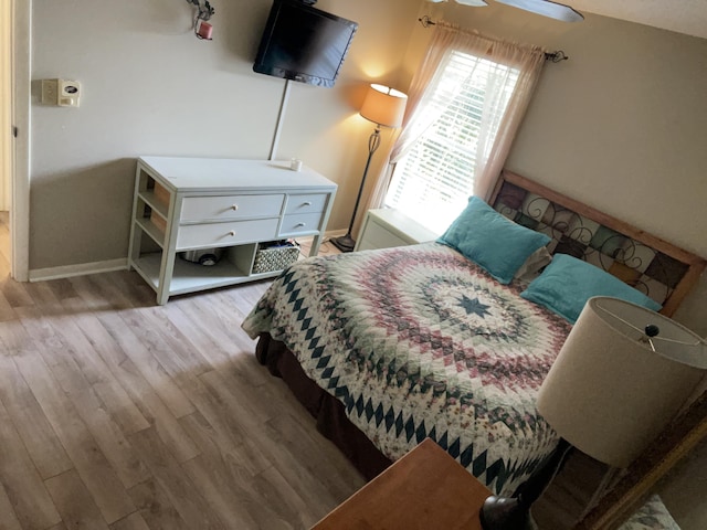 bedroom with baseboards and wood finished floors