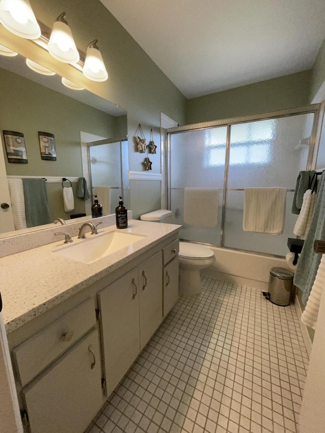 bathroom with toilet, combined bath / shower with glass door, tile patterned flooring, and vanity