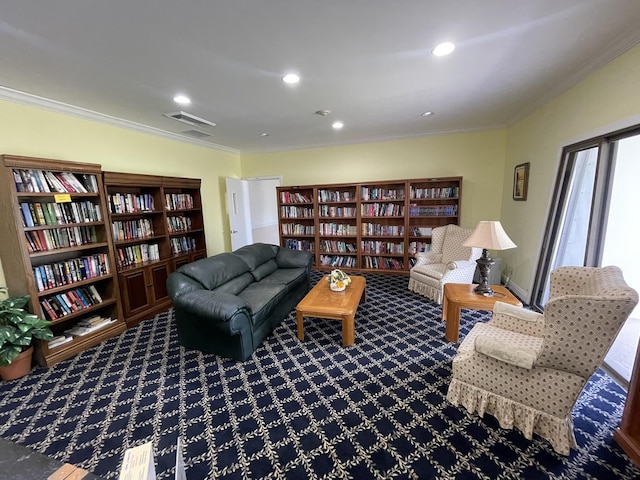 living area featuring recessed lighting, visible vents, wall of books, carpet, and crown molding