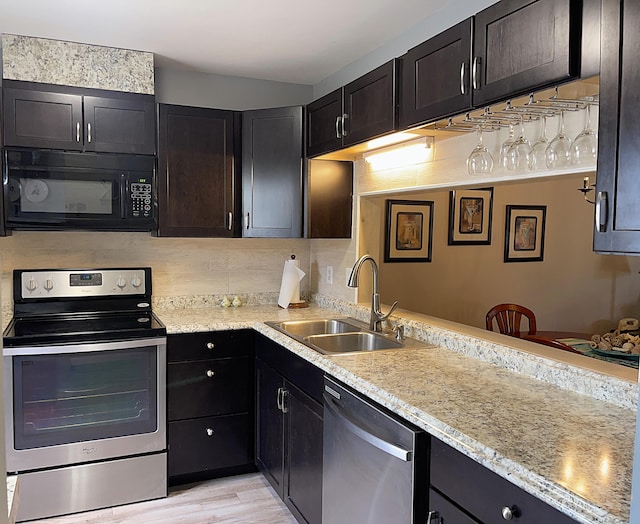 kitchen with light wood-style floors, tasteful backsplash, stainless steel appliances, and a sink