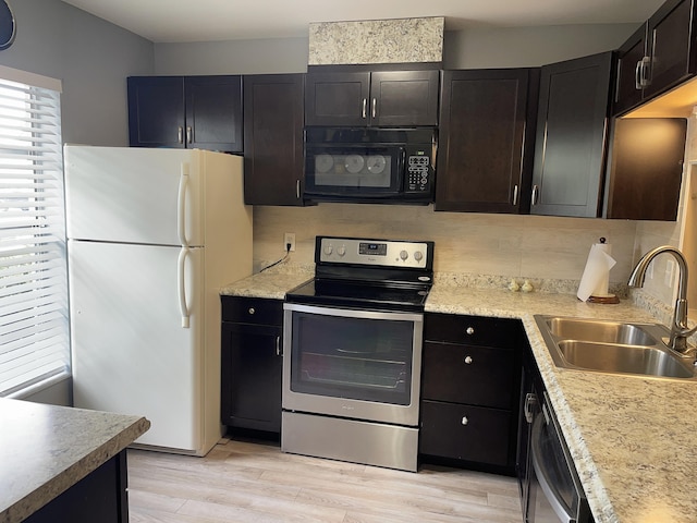 kitchen featuring stainless steel appliances, light countertops, a sink, and light wood-style flooring