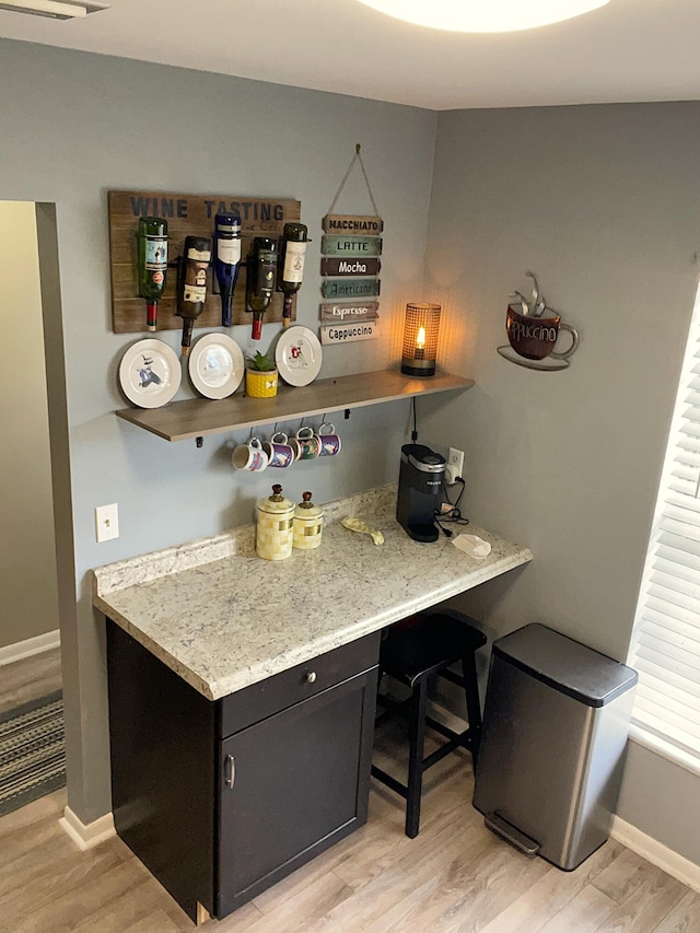 bar featuring light wood-style floors and baseboards