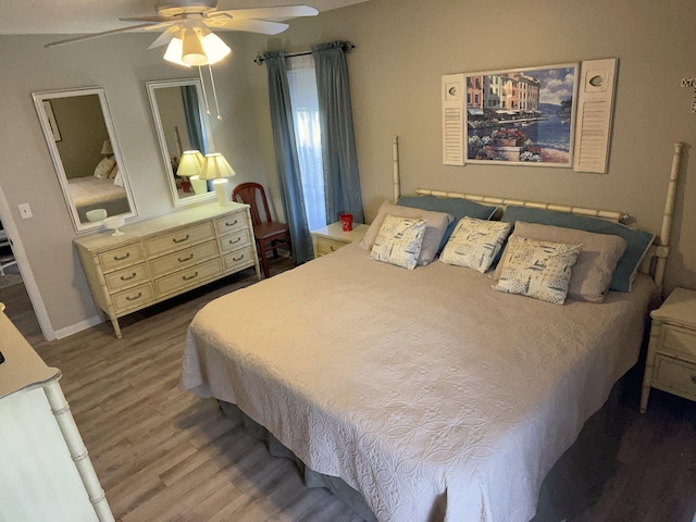 bedroom with a ceiling fan, baseboards, and wood finished floors