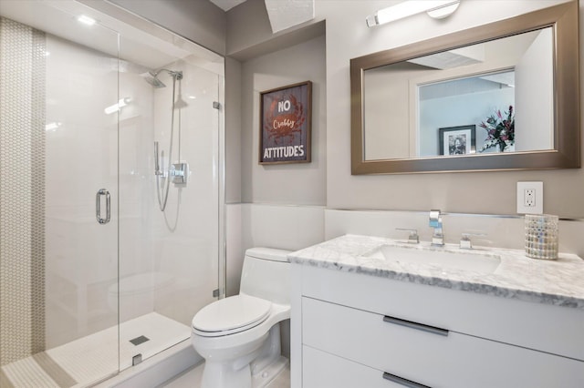 bathroom with a stall shower, toilet, and vanity