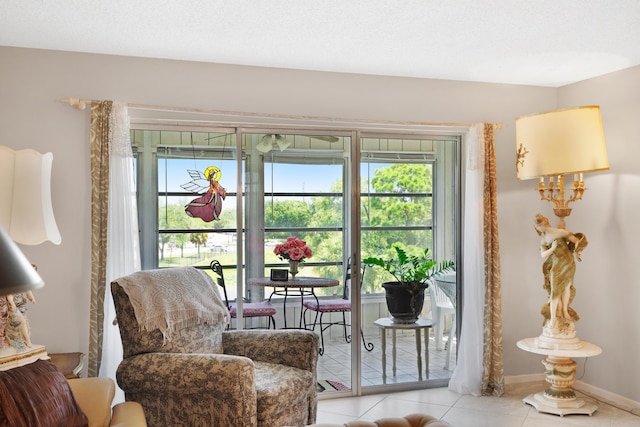 sitting room with a textured ceiling, baseboards, and tile patterned floors