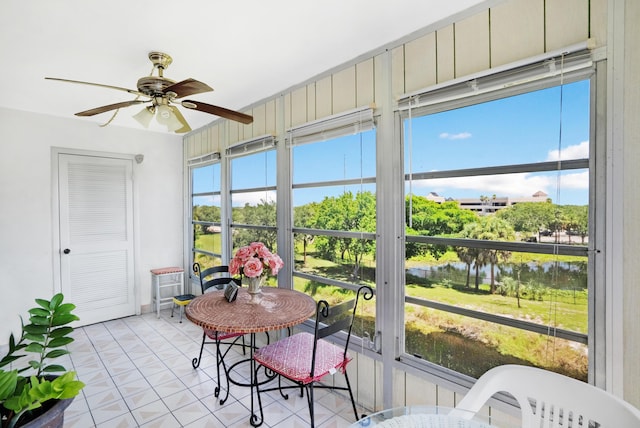 sunroom featuring ceiling fan, a water view, and a wealth of natural light