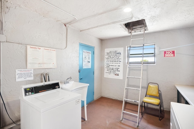 community laundry room with separate washer and dryer, a textured ceiling, and a textured wall