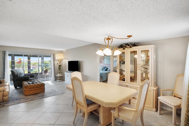 dining area with a chandelier, a textured ceiling, and light tile patterned floors