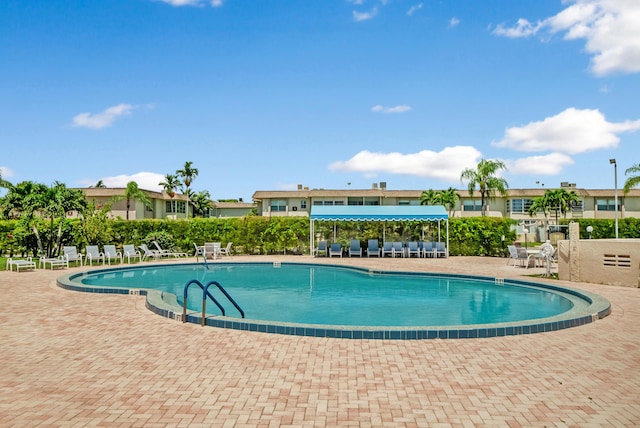 community pool featuring fence and a patio