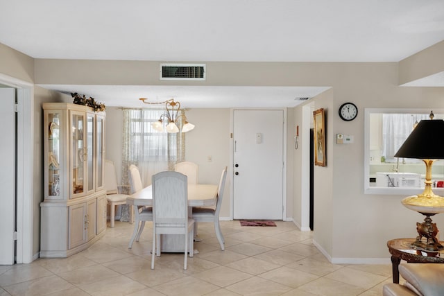 dining area featuring a chandelier, light tile patterned flooring, visible vents, and baseboards