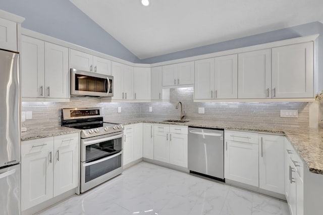 kitchen with light stone counters, marble finish floor, appliances with stainless steel finishes, vaulted ceiling, and a sink