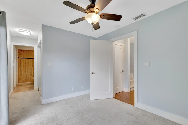 unfurnished bedroom with ceiling fan, carpet, visible vents, and baseboards