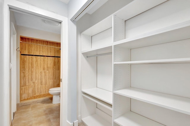 interior space featuring toilet and tiled shower