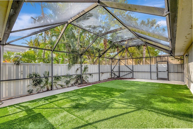 view of yard with glass enclosure and a fenced backyard