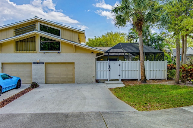 view of front facade with concrete driveway, an attached garage, a gate, fence, and brick siding