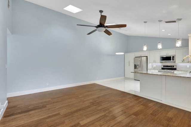 kitchen with stainless steel appliances, tasteful backsplash, light wood-type flooring, and white cabinetry