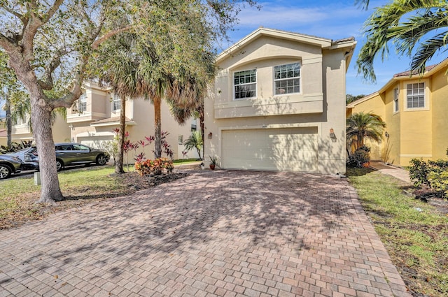 view of front of house featuring a garage, decorative driveway, and stucco siding