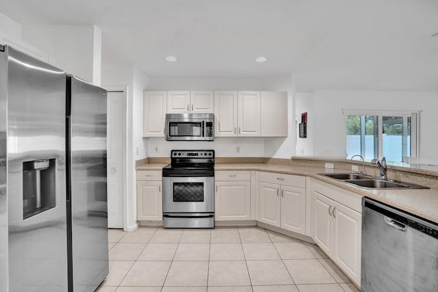 kitchen featuring stainless steel appliances, light countertops, a sink, and light tile patterned floors