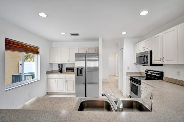 kitchen featuring light tile patterned floors, light countertops, visible vents, appliances with stainless steel finishes, and a sink