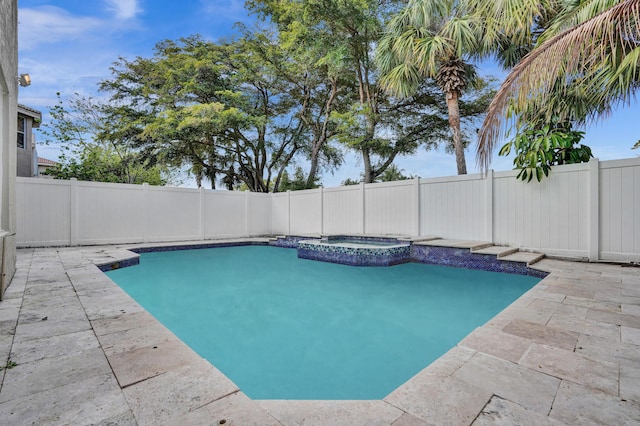 view of swimming pool featuring a pool with connected hot tub, a patio area, and a fenced backyard