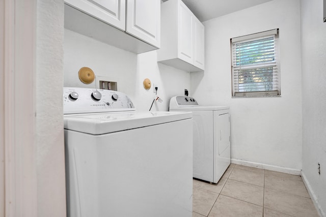 laundry room with light tile patterned floors, washing machine and dryer, cabinet space, and baseboards