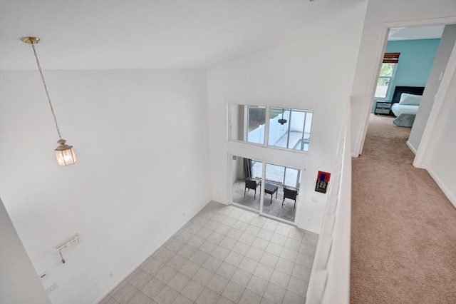 interior space with a towering ceiling, tile patterned flooring, and carpet flooring