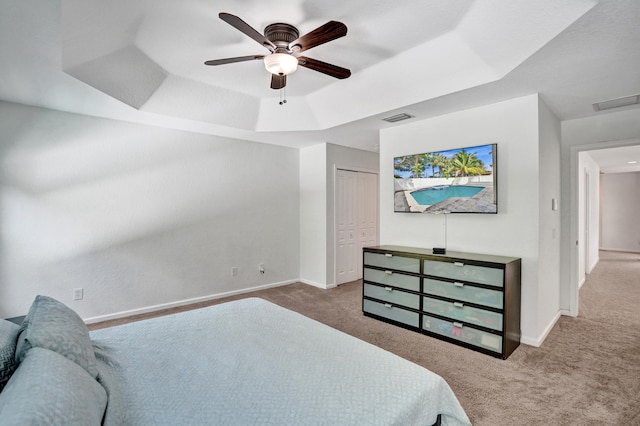 carpeted bedroom with a raised ceiling, visible vents, and baseboards