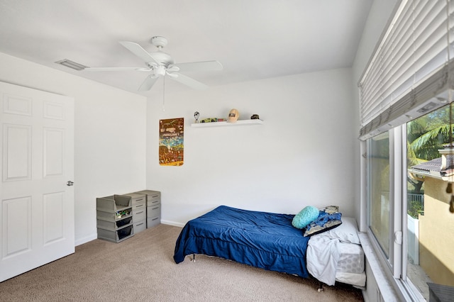 carpeted bedroom with a ceiling fan, visible vents, and baseboards