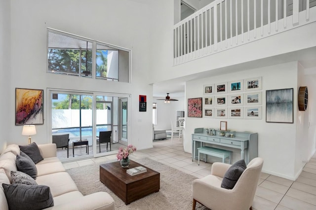 living area with tile patterned flooring, a towering ceiling, and baseboards