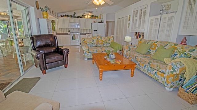 living room with light tile patterned flooring, lofted ceiling, and ceiling fan