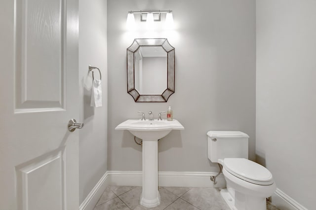 bathroom with tile patterned flooring, toilet, and baseboards