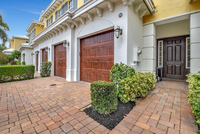 exterior space featuring decorative driveway and stucco siding